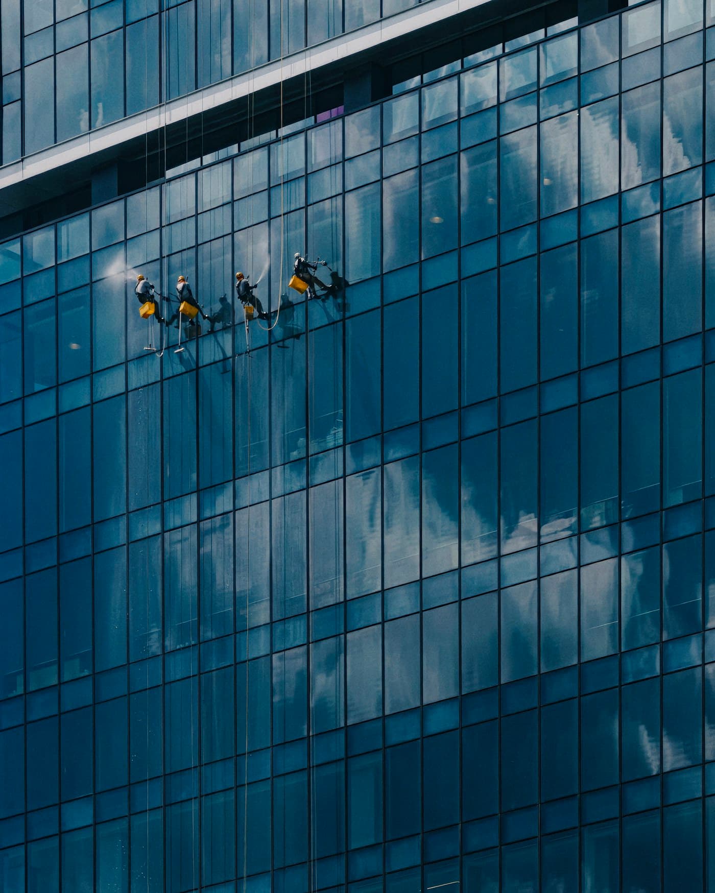 Glasreinigung an einer modernen Gebäudefassade, Stockfoto im Designkonzept
